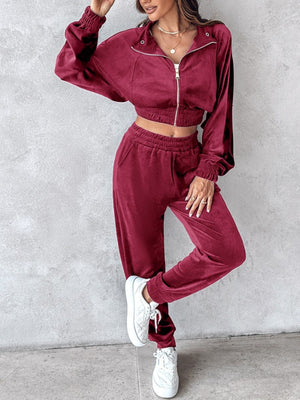 Burgundy velvet crop tracksuit with zipper detail and elastic cuffs.