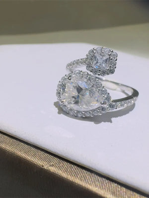 Silver bypass ring with pear and princess cut diamond halo accents