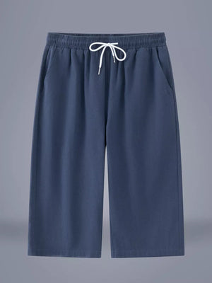 Relaxed fit cropped sweatpants in dark blue with drawstring waist and side pockets.