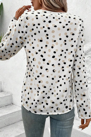 White polka dot blouse with long sleeves and a button-down front.