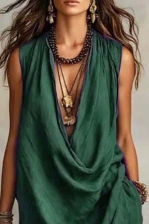 Dark green cowl neck midi dress with pockets, styled with layered necklaces.