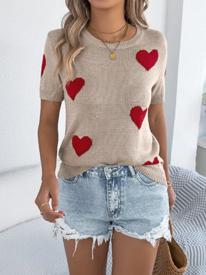 Tan knit t-shirt with red heart pattern and short sleeves.