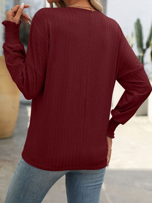 Burgundy textured sleeve blouson top with smocked cuffs.