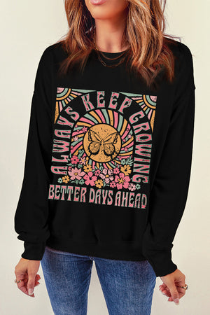 Black crewneck sweatshirt with butterfly and floral graphic and text.