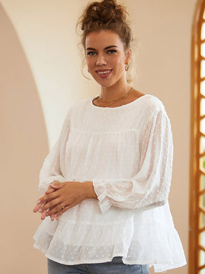 White tiered Swiss dot peasant blouse with long sleeves and ruffled cuffs.