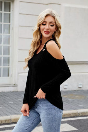 Black ribbed cold-shoulder top with ring detail on strap, paired with jeans.