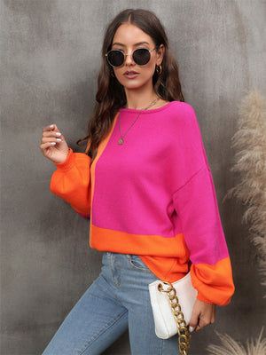 Colorblock knit sweater in hot pink and orange with balloon sleeves.