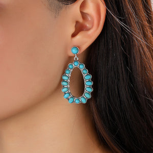 Turquoise teardrop statement earrings with oval turquoise stones and silver alloy setting.