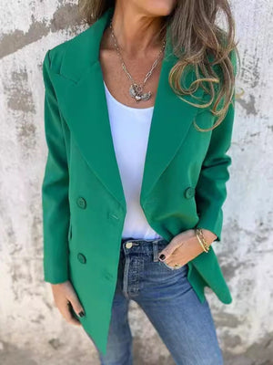Green double-breasted blazer with sculpted lapels and button detail, worn with jeans.