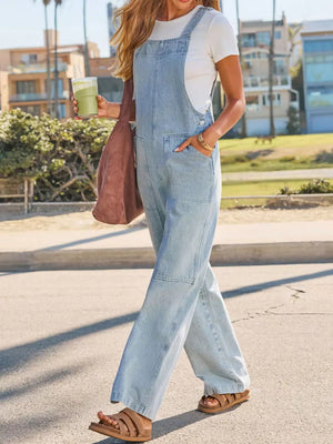 Light wash denim overalls with wide legs and utility pockets.