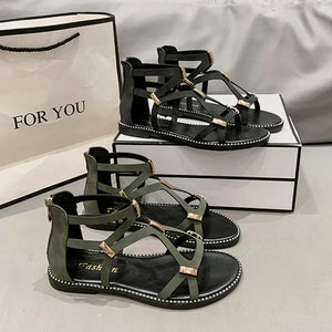 Gladiator zip-back sandals in army green and black with gold accents and strappy design.