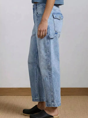 Light wash denim maternity jeans with wide legs and buttoned flap pocket detail.