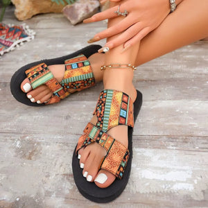 Geometric patterned toe loop sandals with colorful straps and black soles.
