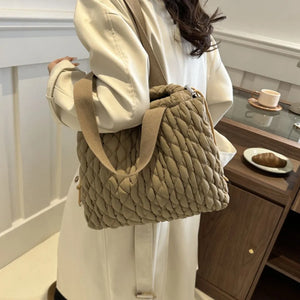 Quilted drawstring carryall bag in khaki with textured diamond pattern and canvas strap.