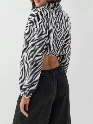 Plush cropped jacket in black and white zebra print with drawstring closure.