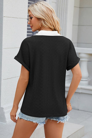 Black perforated panel polo top with white collar and cuffed short sleeves.