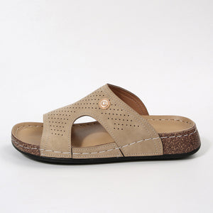 Beige perforated PU leather wedge sandals with a cork wedge and white stitching.