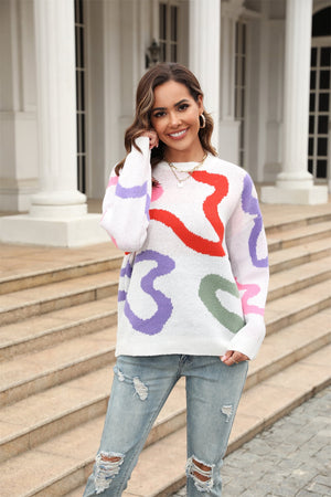 White crewneck sweater with abstract swirl pattern in red, purple, pink, and green.