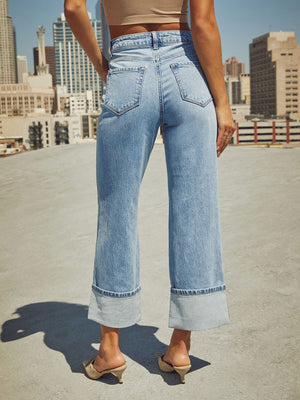 Light wash denim jeans with wide legs and cuffed hems.