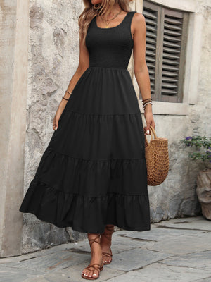 Black smocked bodice tiered maxi dress with a scoop neck and sleeveless design.
