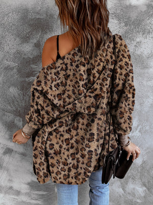 Leopard print plush hooded cardigan with long sleeves and an open front, styled casually.