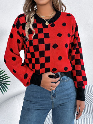 Red checkerboard and dot intarsia knit sweater with black trim and crew neck.