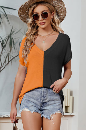 Split-tone knit tee with V-neck and dolman sleeves in orange and black.