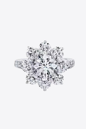 Silver moissanite engagement ring with a central round cut stone surrounded by a petal cluster of smaller stones.