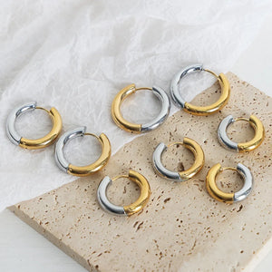 Two-tone segmented hoop earrings in gold and silver metal.