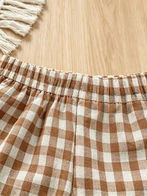 Brown gingham baby shorts with elastic waistband and ruffle trim detail.