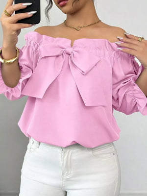 Pink off-the-shoulder blouse with ruffled bow and cinched sleeves.