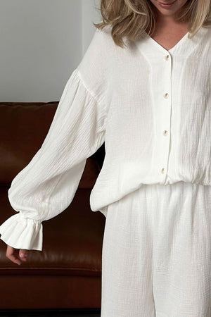 White gauze loungewear set with voluminous sleeves and ruffled cuffs.