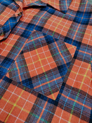 Orange plaid shacket with relaxed fit and chest pocket.