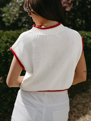 White knit sweater vest with red trim, mock neck, sleeveless, acrylic.