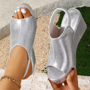 Sleek silver high heel wedge sandals with peep toe and slingback strap.