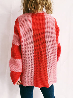 Vertical stripe waffle knit sweater in red and pink acrylic, crew neck, long sleeves.