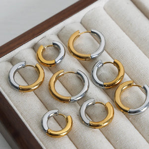 Two-tone segmented hoop earrings in gold and silver metal.
