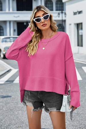 Hot Pink acrylic knit sweater with flared sleeves and slit hem detail.