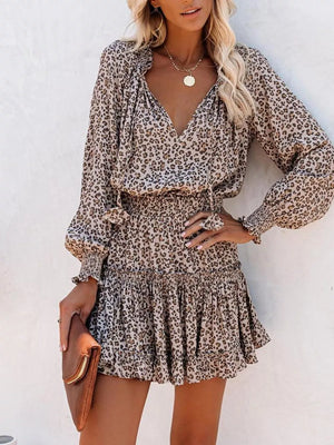 Leopard print tiered mini dress with ruffled neckline and smocked waist.