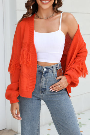 Orange acrylic cardigan with fringe sleeves and textured knit detail.