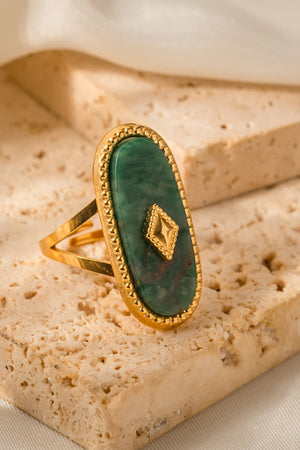 Gold-plated ring with oval green stone and diamond accent detail