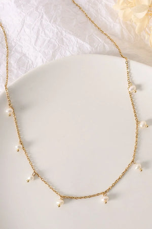Gold chain necklace with dangling pearl accents
