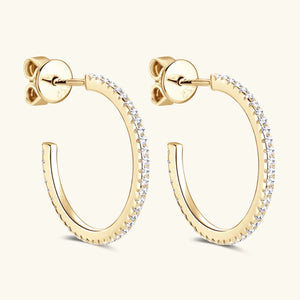 Gold C-hoop earrings with pavé-set stones.