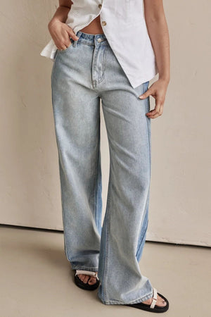 Light wash denim wide-leg trousers with contrast paneling and a relaxed fit.