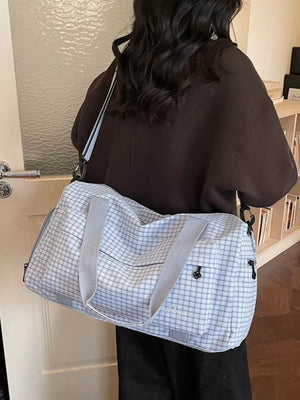 Elegant plaid travel bag with versatile straps and grey handles.