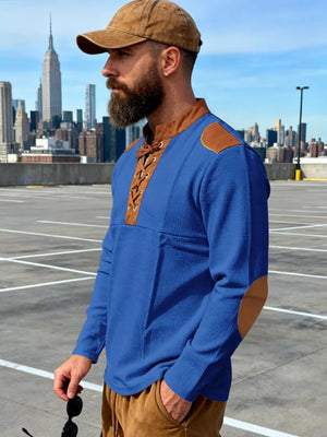 Blue long-sleeve men's t-shirt with lace-up neckline and brown elbow patches.