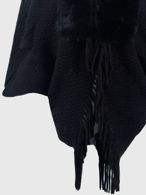 Black textured knit poncho with faux fur collar and fringe detail.