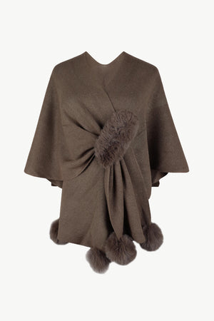 Taupe knit cape with fur trim and pom-poms.