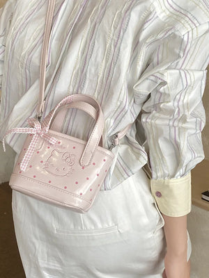 Charming mini crossbody bag in blush pink with Hello Kitty detail and bow.