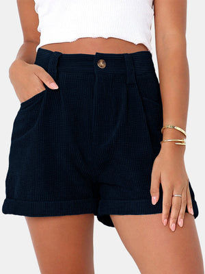 Dark Navy corduroy pleated high-waist shorts with cuffed hems and button closure.